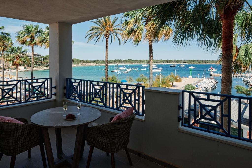 The rooftop bar terrace at Honucai, a table set between blue railings and palms, the marina and open sea filling the view
